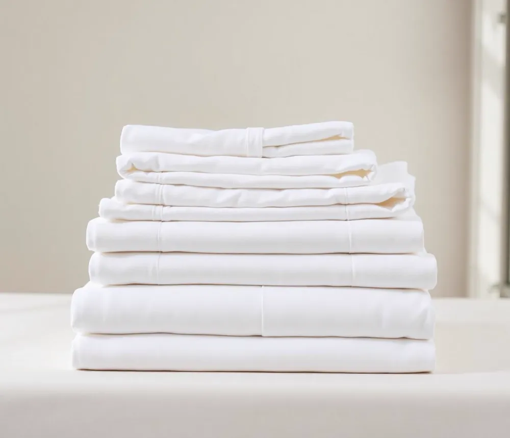 Stack of freshly folded crisp white hotel linen and towels
